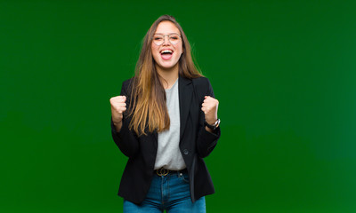 young pretty woman looking happy and friendly, smiling and winking an eye at you with a positive...