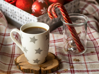 Christmas cup of hot coffee and candy canes on a plaid. Festive backdrop for holidays. Christmas composition. Image for display your christmas products.