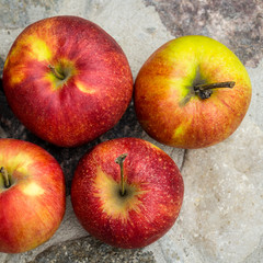 Group of fresh red apples lying on a stone table