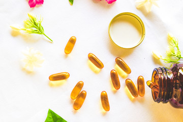 Fish oil omega 3 capsules decorated with colorful flowers for healthy lifestyle concept