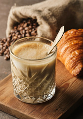 Glass of latte coffee with croissant.