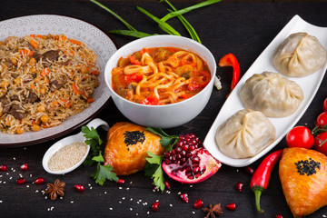 The concept of Eastern asian festive cuisine. Assorted Uzbek food set, pilaf, samsa, lagman, manta, shurpa restaurant concept, Uzbek food. Homemade Eastern arabic new year and Christmas dish from lamb