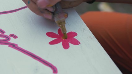 Drawing flower finishing touches on sign