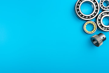 Ball bearing lying on a blue background with copy space on the left side. Flat view from above.