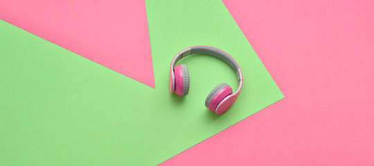 Minimal fashion, Trendy pink headphones. Music vibration on geometry background. Hipster DJ accessory Flat lay. Art creative summer vibes, fashionable pop art style. Pink design color