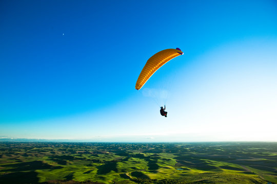 Man paragliding over hills