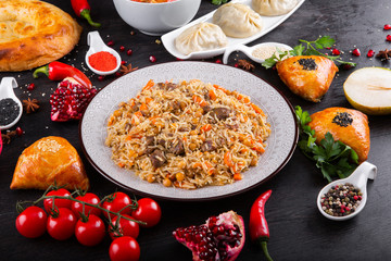 The concept of Eastern asian festive cuisine. Assorted Uzbek food set, pilaf, samsa, lagman, manta, shurpa restaurant concept, Uzbek food. Homemade Eastern arabic new year and Christmas dish from lamb