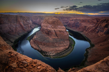 Sunset at Horseshoe Bend, Page Arizona. The Colorado River and a land mass made of orange sandstone. 
