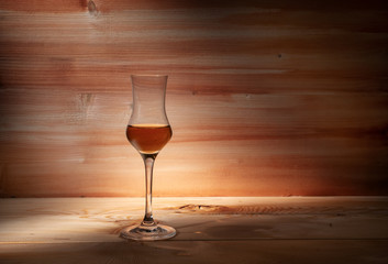 Glass of whiskey on a wooden background