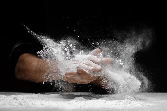 Chef clap white flour dust man hand on black background