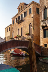 Fototapeta na wymiar Venice, Italy. Boats and low bridge on a channel