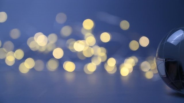 A rolling earthball globe of usa and europe in front of blue background with golden lights - christmas or eve 2025.