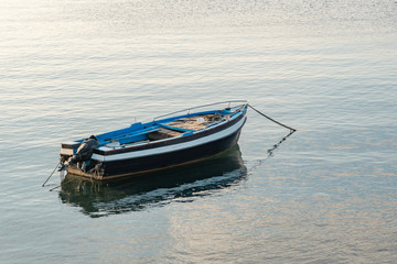 Fishing boat floating on the Mediterranean sea shore. Italy.
