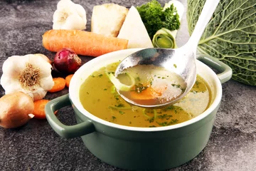 Foto op Plexiglas Broth with carrots, onions various fresh vegetables in a pot - colorful fresh clear spring soup. Rural kitchen scenery vegetarian bouillon stock © beats_