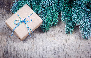 Christmas gift and fir branches. Gift box on wooden background copy space