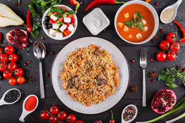 The concept of Eastern asian festive cuisine. Assorted Uzbek food set, pilaf, samsa, lagman, manta, shurpa restaurant concept, Uzbek food. Homemade Eastern arabic new year and Christmas dish from lamb