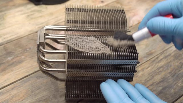 Old computer system unit cooler with dust inside. Dust on the computer cooler computer processor, the master removes it with a brush.