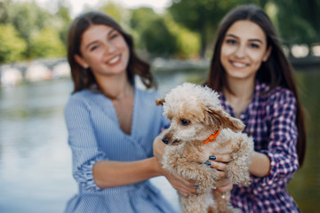 Beautiful girl in a blue dress. Women in a summer park. Ladies with a dog