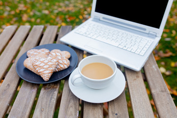 cup of coffee and cookies with laptop computer