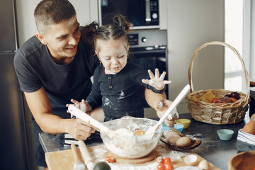 Family in a kitchen. Handsome father with little daughter