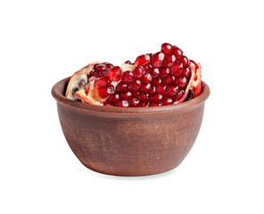pomegranate slices with ripe grains in a clay bowl isolated on a white background
