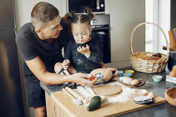 Family in a kitchen. Handsome father with little daughter