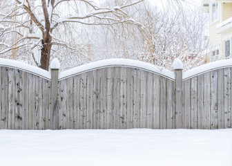Wooden board fence in a winter landscape.