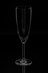 An empty clean champagne glass on a black background.