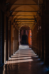 Portico passage with roman style columns with morning sunlight in Bologna, Italy