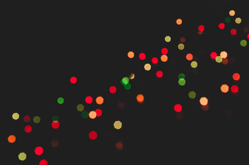 unfocused blurred glowing shiny red, green and yellow sparkles for wallpaper and design isolated on black