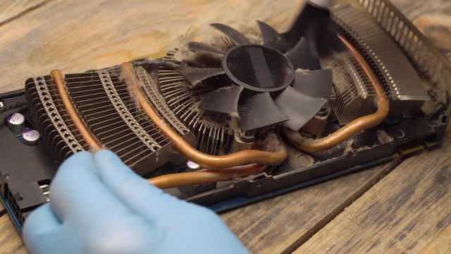 The wizard removes dust on the processor, fan of the computer or video card with a brush and vacuum cleaner.