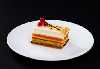 multi layered beautiful cake with white cream and red currants, on a white plate, dessert serving