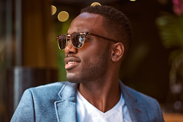 Portrait of young confident american businessman in sunglasses and blue blazer.