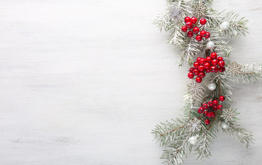 Fototapeta na wymiar Fir branch with Christmas decoration on white shabby wooden board. Christmas background with copy space for text. Flat lay.