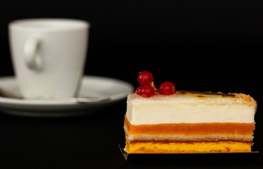 multilayer cake with airy white cream and red currant, mouth watering dessert, white cup with a small spoon