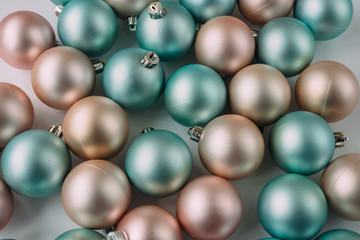Christmas balls of mint and peach color on a light background.