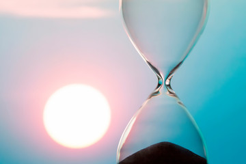 Hourglass on the background of a sunset. The value of time in life. An eternity.