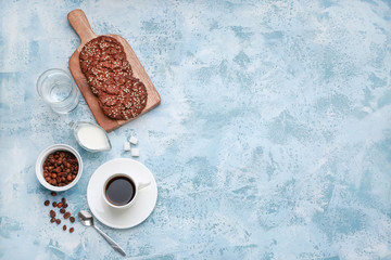 Cup of hot coffee with milk and cookies on color background