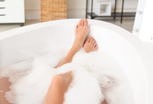 Beautiful young woman relaxing in bathtub