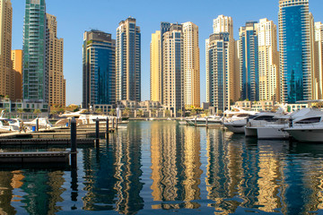Dubai Marina district with beautiful buildings and yachts. Dubai Marina pier.