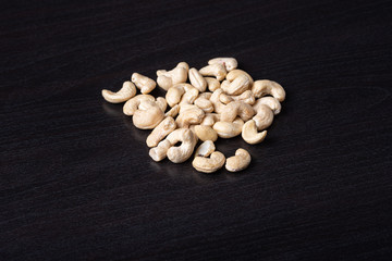 Cashewkerne auf dem schwarzen Holzbrett