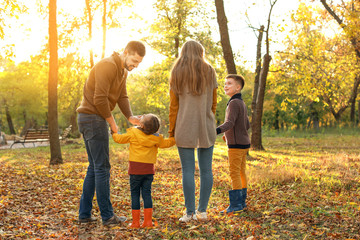 Happy family walking in autumn park