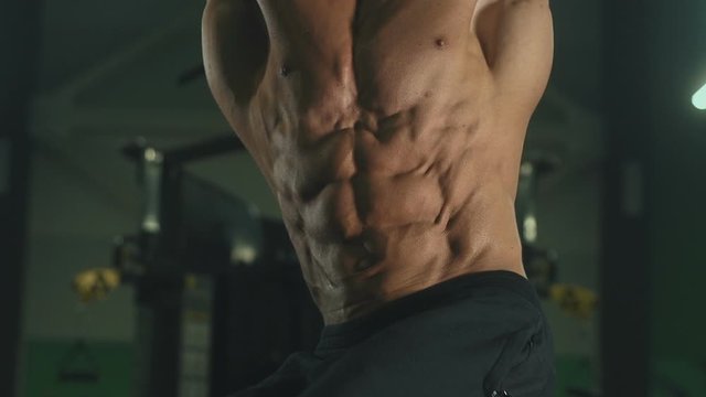 Handsome strong athletic men pumping up muscles workout fitness and bodybuilding concept background - muscular bodybuilder fitness men doing abs exercises in gym naked torso