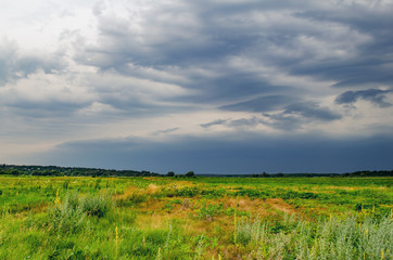 Dark rain storm clouds over the field