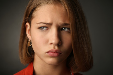 Sad teenage girl on dark background, closeup