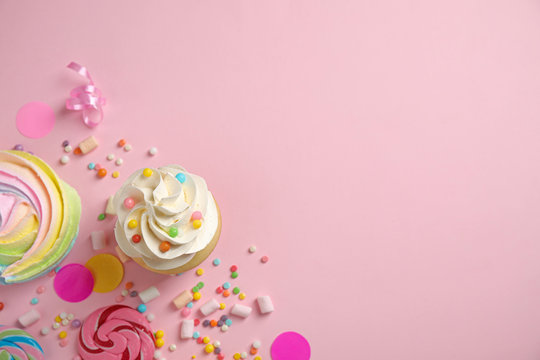 Flat lay composition with cupcake on pink background, space for text. Birthday party
