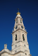 Fototapeta na wymiar Torre de templo português com relógio, sino, coroa e cruz, Nossa Senhora de Fátima