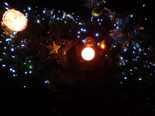 Ambiance de noël et de fête avec étoile, boules, lumières et bougies qui scintillent dans la...