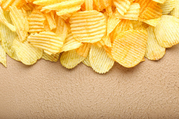 Tasty potato chips on color background