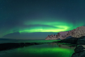 Obraz na płótnie Canvas Northern lights, Aurora Borealis, Devil Teeth mountains in the background, Tungeneset, Senja, Norway